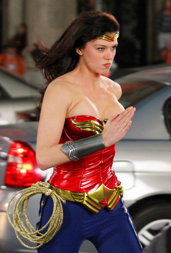 Adrianne Palicki dashes around set and shows off her figure in her iconic Wonder Woman costume of a metallic red patent leather bustier top and blue star-detailed leggings during overnight filming of the TV series "Wonder Woman" in downtown LA. Adrianne donned the revamped costume including red boots, armbands, shimmery gold whip and crown for the shoot which also saw a stunt woman run over a car being chased by another actor. Adrianne, who smiled and waved to photographers, spoke with the director and later put on a black jacket to keep warm in between scenes. Los Angeles, CA. 03/29/11.